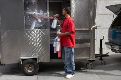 Men stock a food cart in Brooklyn, NY
