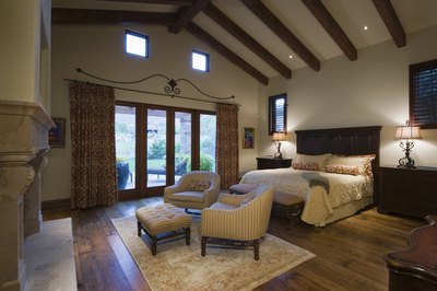 Large bedroom with exposed wood beam ceiling.