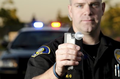policeman holding up breathalyzer