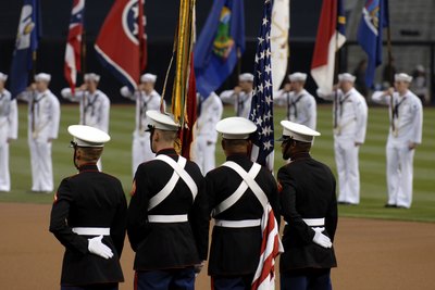 Individuals in the military perform the military salute for the entirety of the anthem