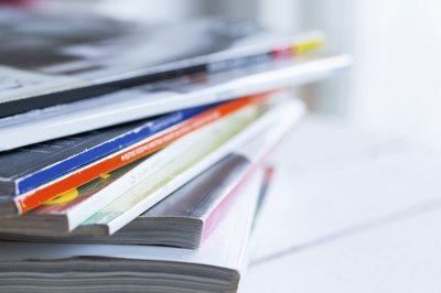 A pile of catalogs on a table.