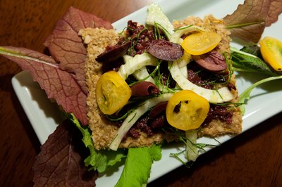 Flax seed cracker topped with olive tapenade