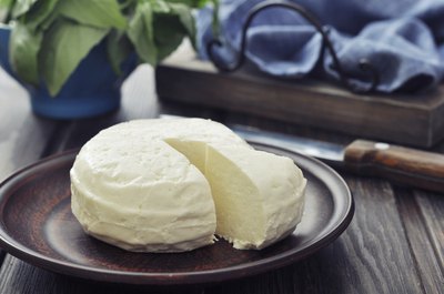 Bel paese cheese round on small plate.