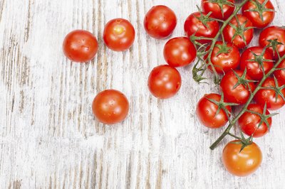 Small pile of cherry tomatoes on table top.