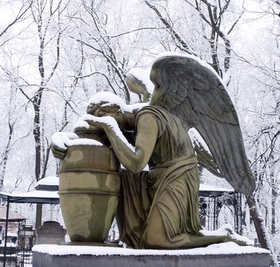 A statue of a weeping angel in winter.