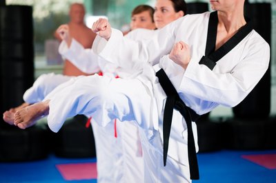 Students in a martial arts class kicking.