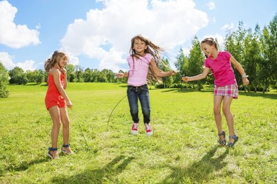 Young children playing jump rope.