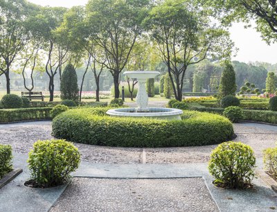 Paved walkways and a central fountain accentuating an English garden.