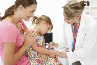 mother holding daughter for doctor