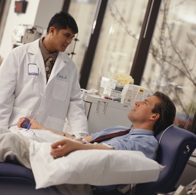 A doctor talks to a patient that is donating blood.