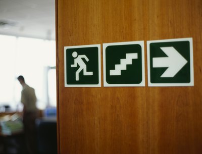 A fire exit sign on a wooden door.