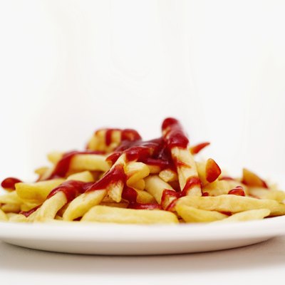 A plate of French fries covered in ketchup.