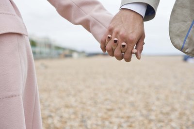 Couple holding hands on the beach