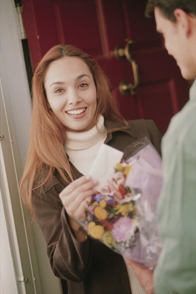 Woman receiving flowers from delivery man