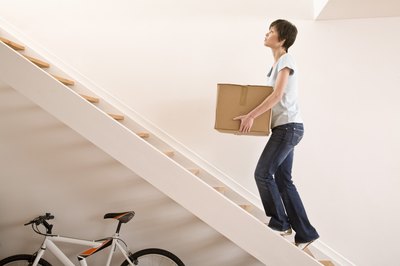 Woman carrying box up stairs