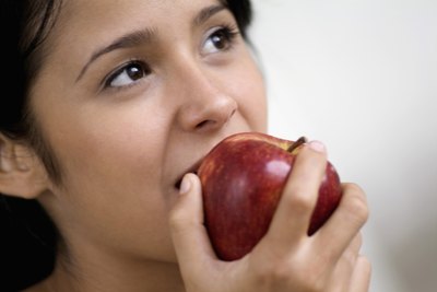 A teenage girl biting into an apple.