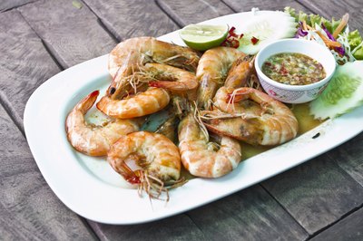 Plate of stewed shrimp on table.