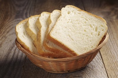 A basket filled with slices of white bread.