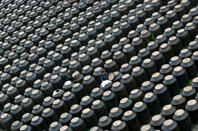 Workers inspect vinegar tanks in fermentation room of vinegar factory