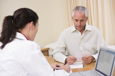 Doctor writing prescription for patient