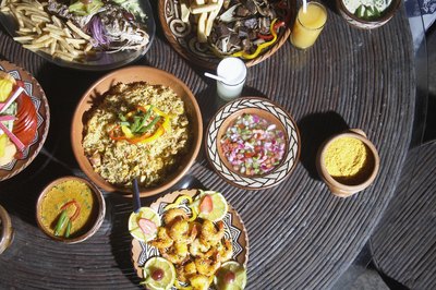 A birds eye view of Honduran dishes served with a bowl of chimole on a rustic table.