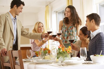 Adults toasting at a dinner party.