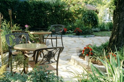A private patio in a shrub lined backyard.