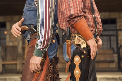 Two men dressed as cowboys standing back to back