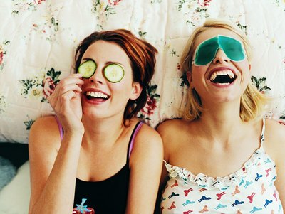 Teenage girls laughing on bed