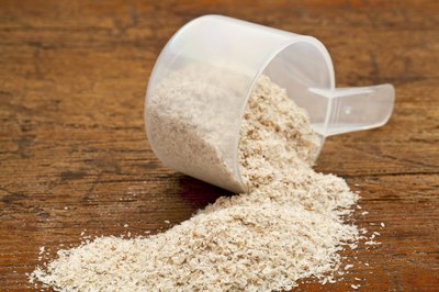Psyllium seed husks spilling from a measuring scoop