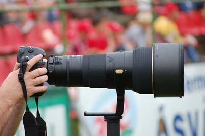 Sports photographer using large zoom lens