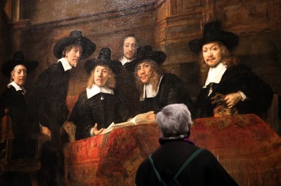 A woman looking at a Rembrandt in a gallery.