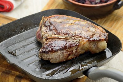 Steak being cooked on small pan.