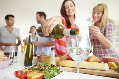 Woman pours some wine at a party