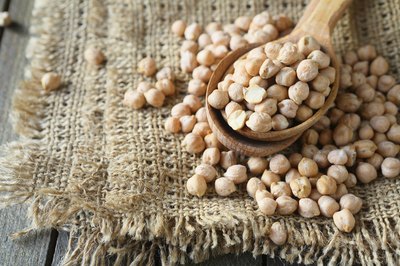 Spoonful of chickpeas on top of burlap bag.