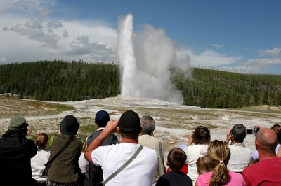 Tourists watch eruption of Old Faithful geiser in Yellowston National Park, WY