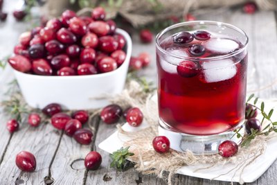 Cranberry juice and a bowl of cranberries.