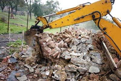 An excavator removes debris from a demolition site.