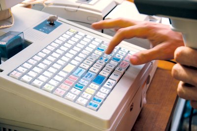 A cashier prepares the till before starting a shift.