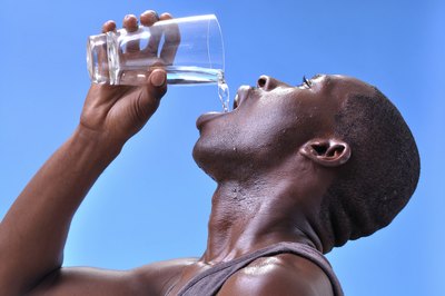 Dehydrated young man drinking water.