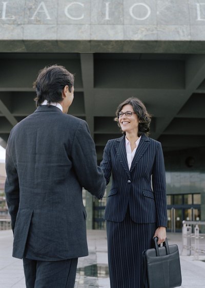 Businessman and businesswoman shaking hands.
