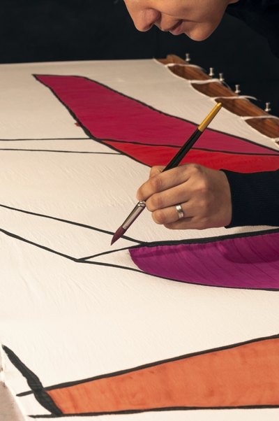 Close-up of a woman's hand painting a cloth banner