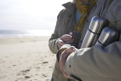 Man holding two thermoses