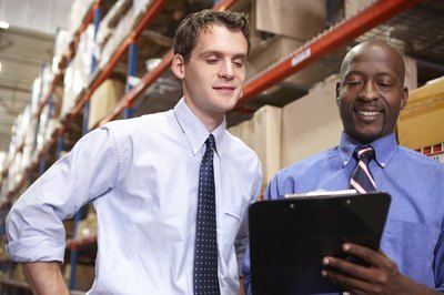 Manager with staff member in warehouse