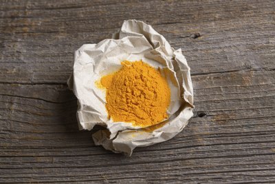 Ground turmeric on brown paper.