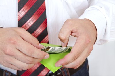 A man puts cash in an envelope.