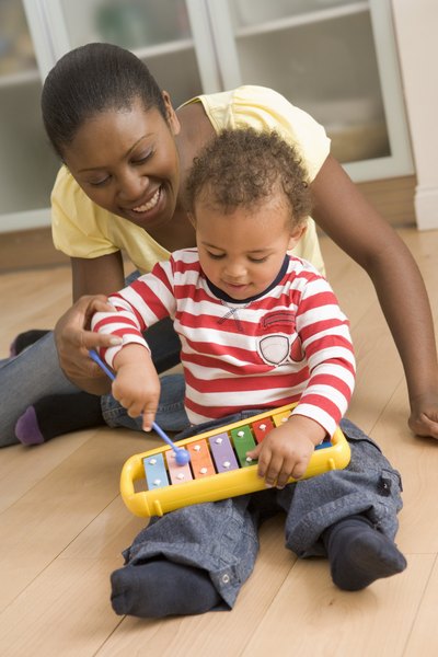 Mother and baby playing with toy xylophone