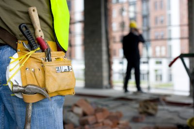 A close-up of a worker wearing a tool belt.