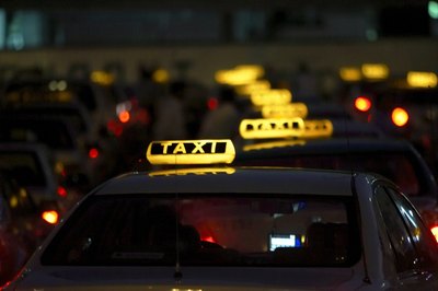 A row of taxis at night.