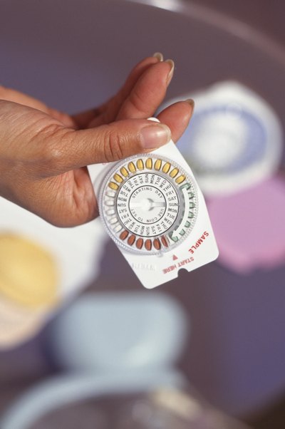 Woman holding oral contraceptives